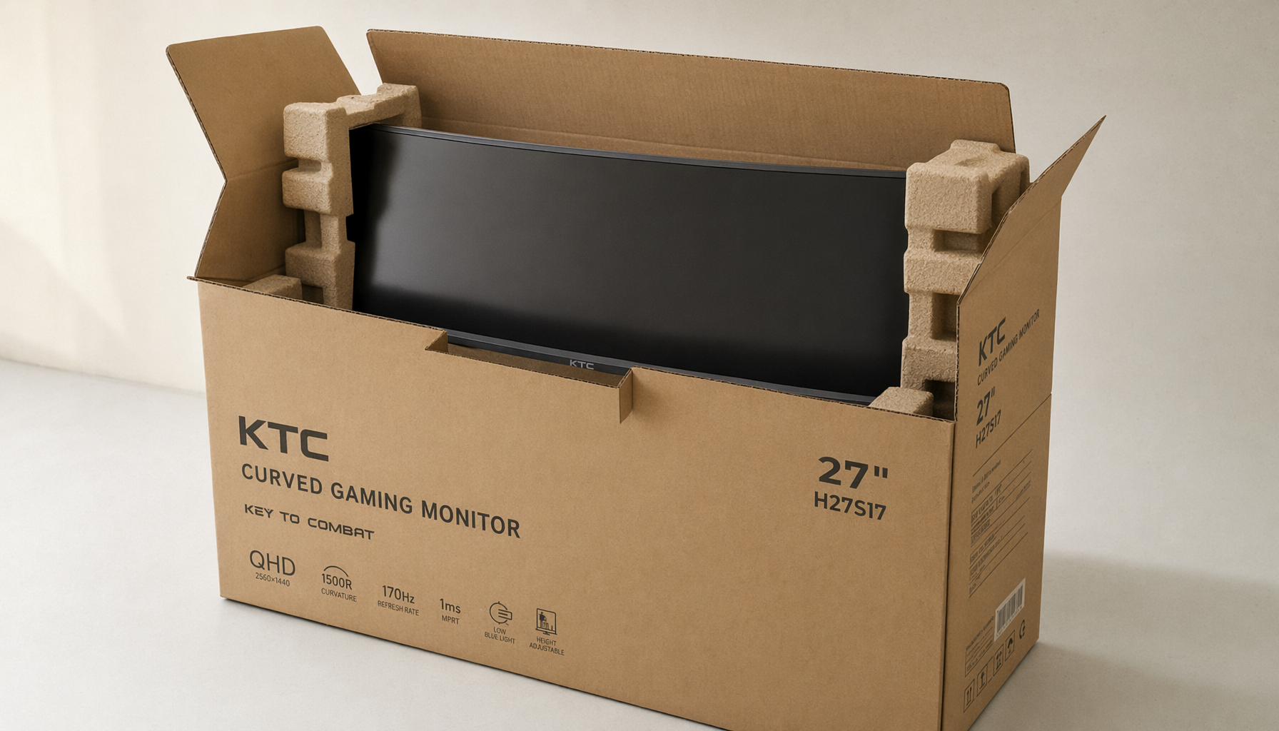 A gaming monitor lifted from eco-friendly molded fiber packaging, showing plastic-free paper-based inserts and a recyclable corrugated carton