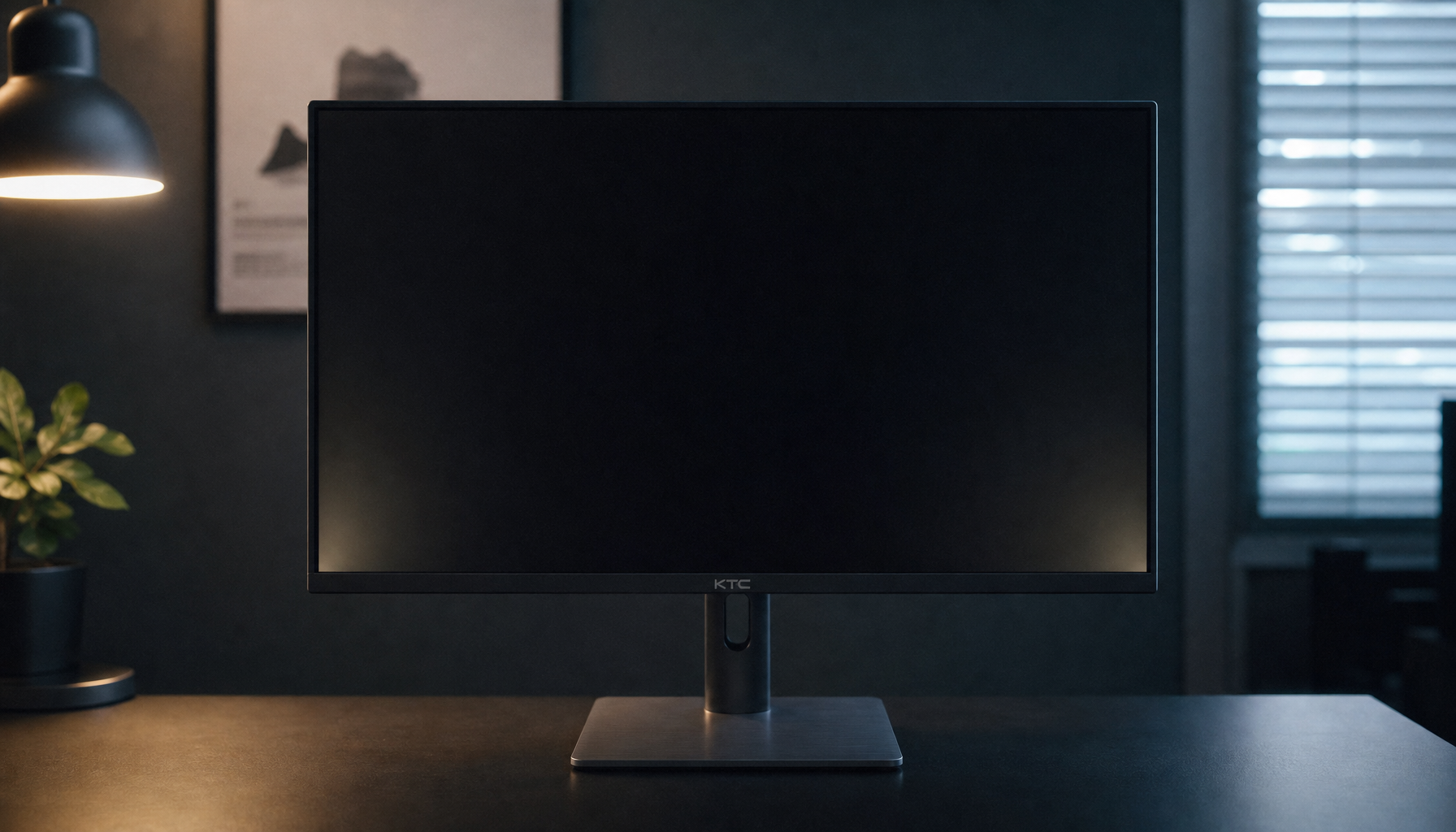Gaming monitor displaying a black test screen on a desk, with faint backlight bleed visible at the corners